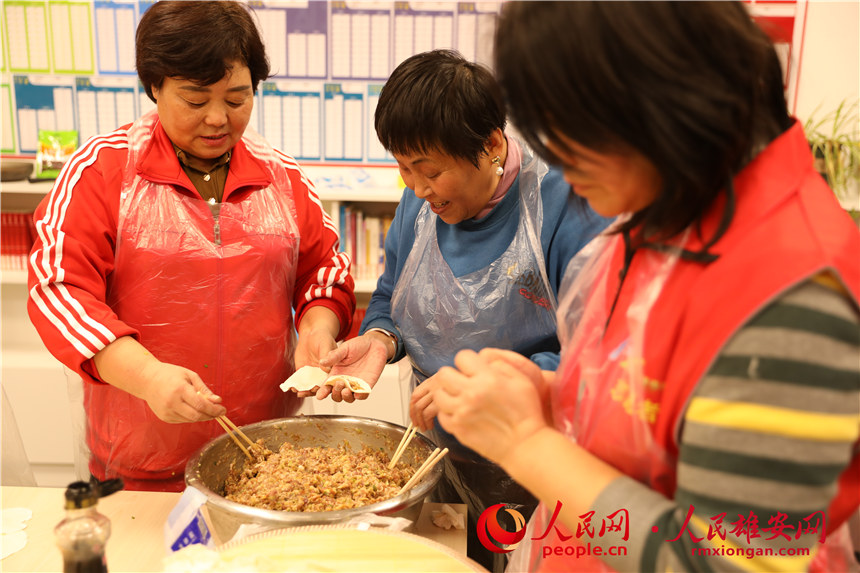 圖為容西片區(qū)飛泉社區(qū)組織回遷居民包餃子。人民網(wǎng) 楊華龍攝