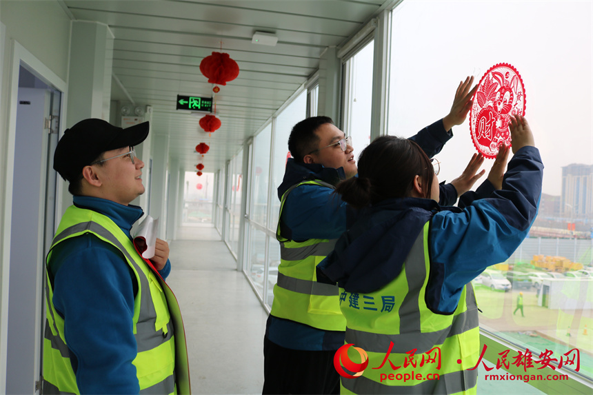 建設(shè)者們正在貼窗花。中建三局集團北京有限公司供圖