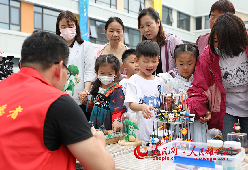 5月31日，雄安容和樂安幼兒園舉辦傳統(tǒng)文化游園活動。活動邀請了雄安當?shù)胤沁z文化傳承人走進幼兒園，與孩子和家長交流互動。通過現(xiàn)場接觸非遺項目，讓孩子們零距離認識非遺、熟悉非遺，感受非遺之美。人民網(wǎng) 李兆民攝