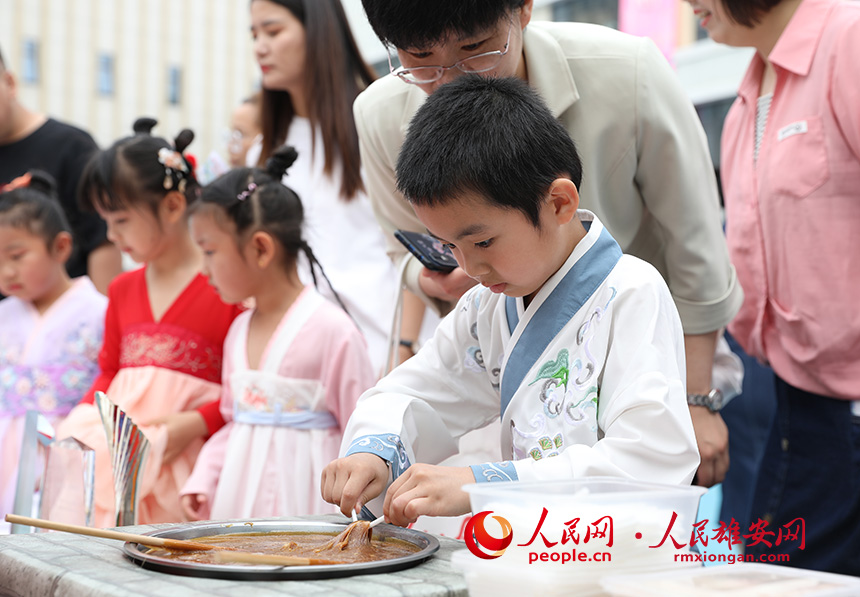 5月31日，雄安容和樂(lè)安幼兒園舉辦傳統(tǒng)文化游園活動(dòng)?；顒?dòng)邀請(qǐng)了雄安當(dāng)?shù)胤沁z文化傳承人走進(jìn)幼兒園，與孩子和家長(zhǎng)交流互動(dòng)。通過(guò)現(xiàn)場(chǎng)接觸非遺項(xiàng)目，讓孩子們零距離認(rèn)識(shí)非遺、熟悉非遺，感受非遺之美。人民網(wǎng) 李兆民攝