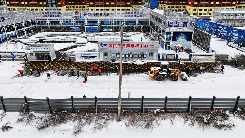 雄東安置房B單元項(xiàng)目組織建設(shè)者開展清雪除冰工作。中國五冶供圖